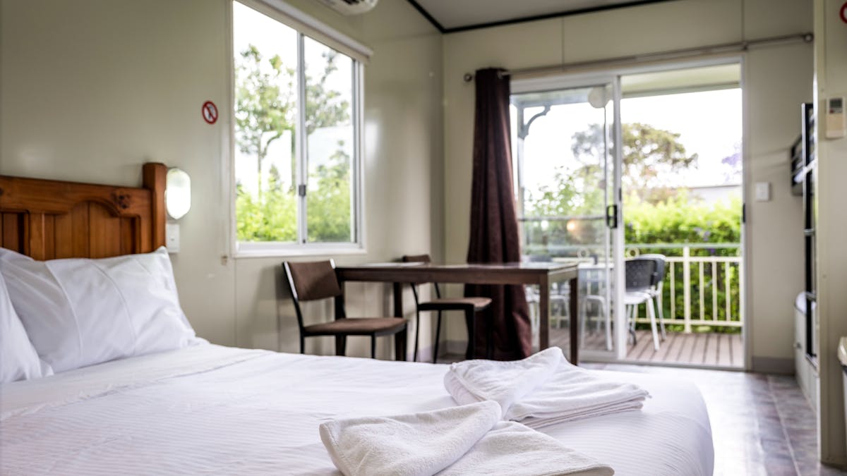 Our four berth cabin's double bed, with a view of the outdoor balcony area.