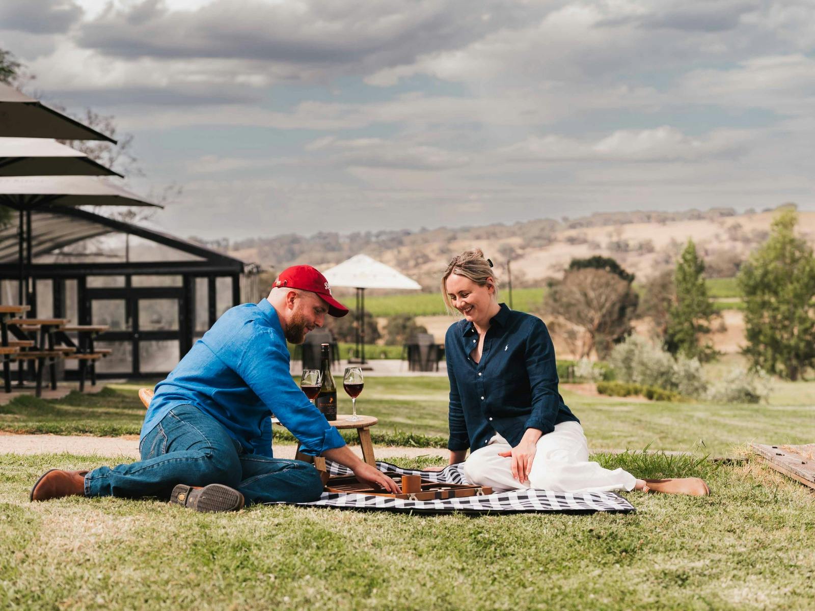 Couple playing game on a picnic blanket enjoying wine at Stockmans Ridge Wines