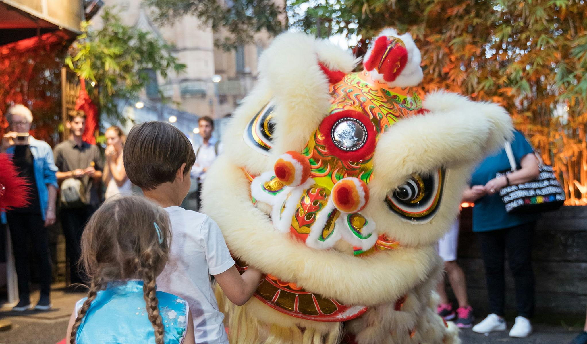 Lion dancer playing with children
