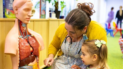 A young girl and woman exploring a human dummy