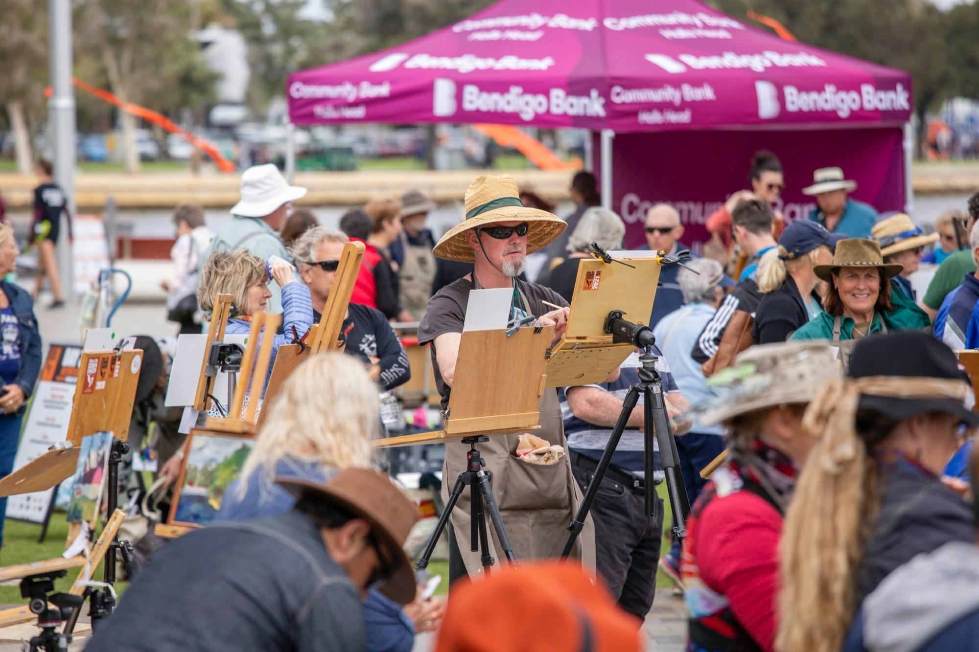 People outdoors drawing in a completion at Plein Air Down Under