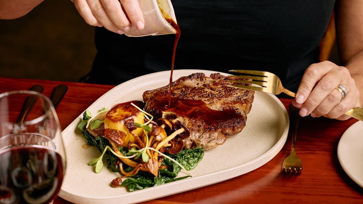 Pouring sauce on a steak