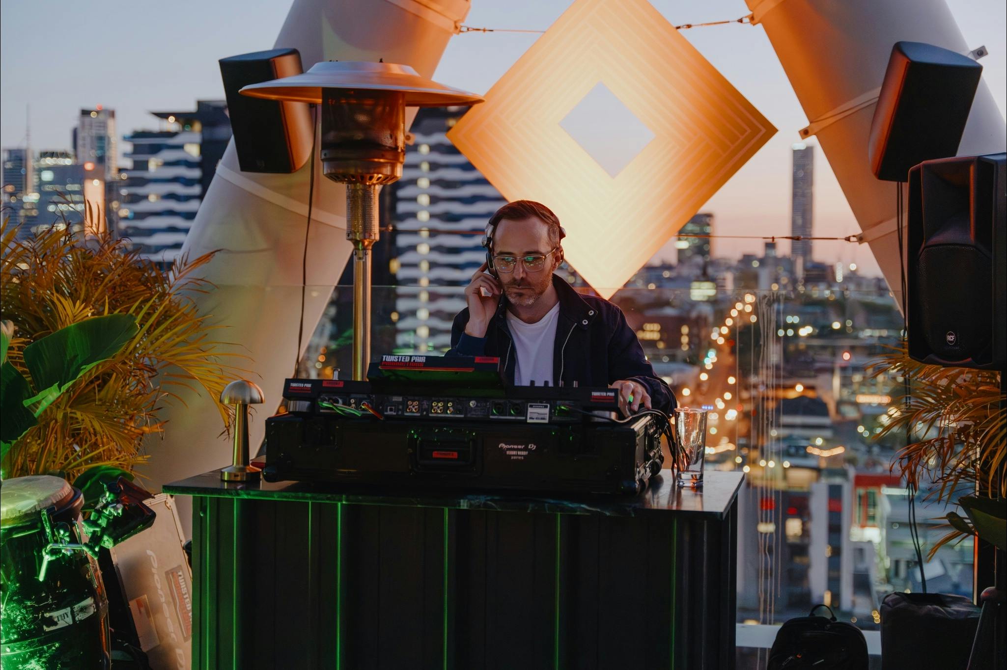 Live DJ playing with the sunset and city views in the back