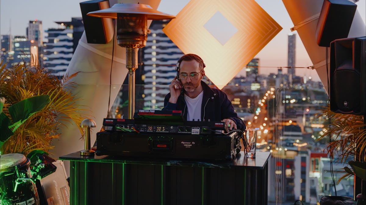 Live DJ playing with the sunset and city views in the back Live DJ playing with the sunset and city views in the back