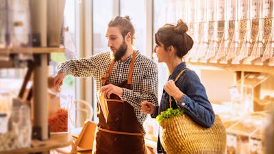 Man wearing checkered shirt serving lady wearing denim jacket