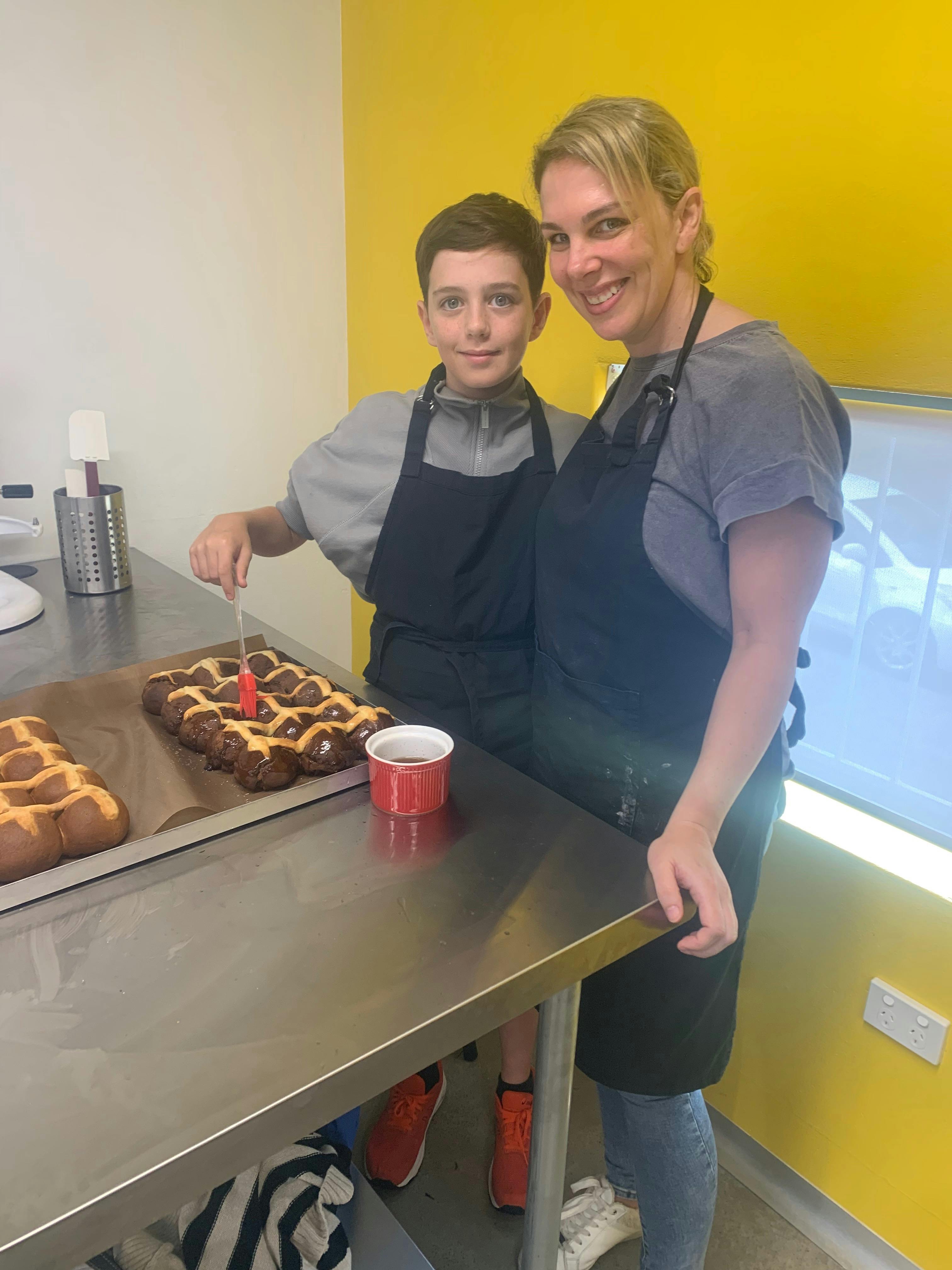 Mother and child in kitchen with the hot cross buns they have just made