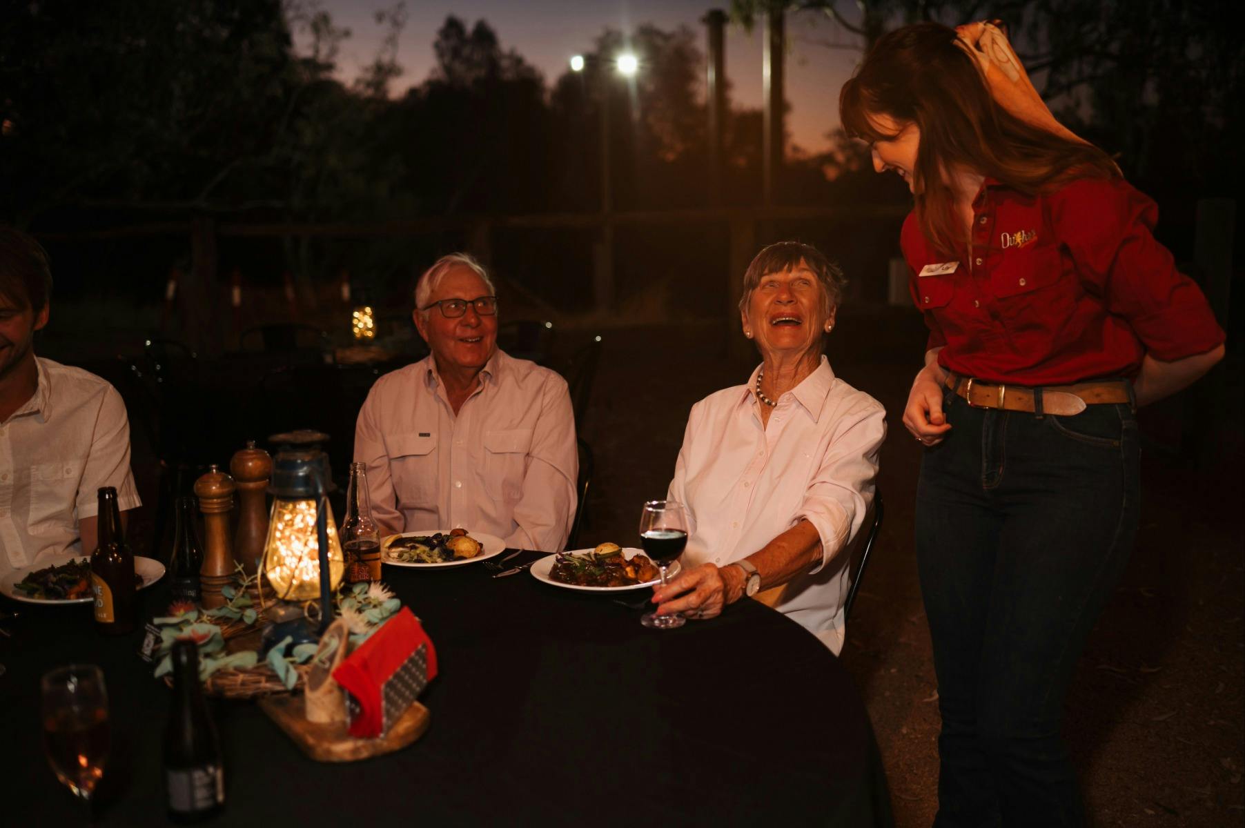 Guests and staff member laughing at a table