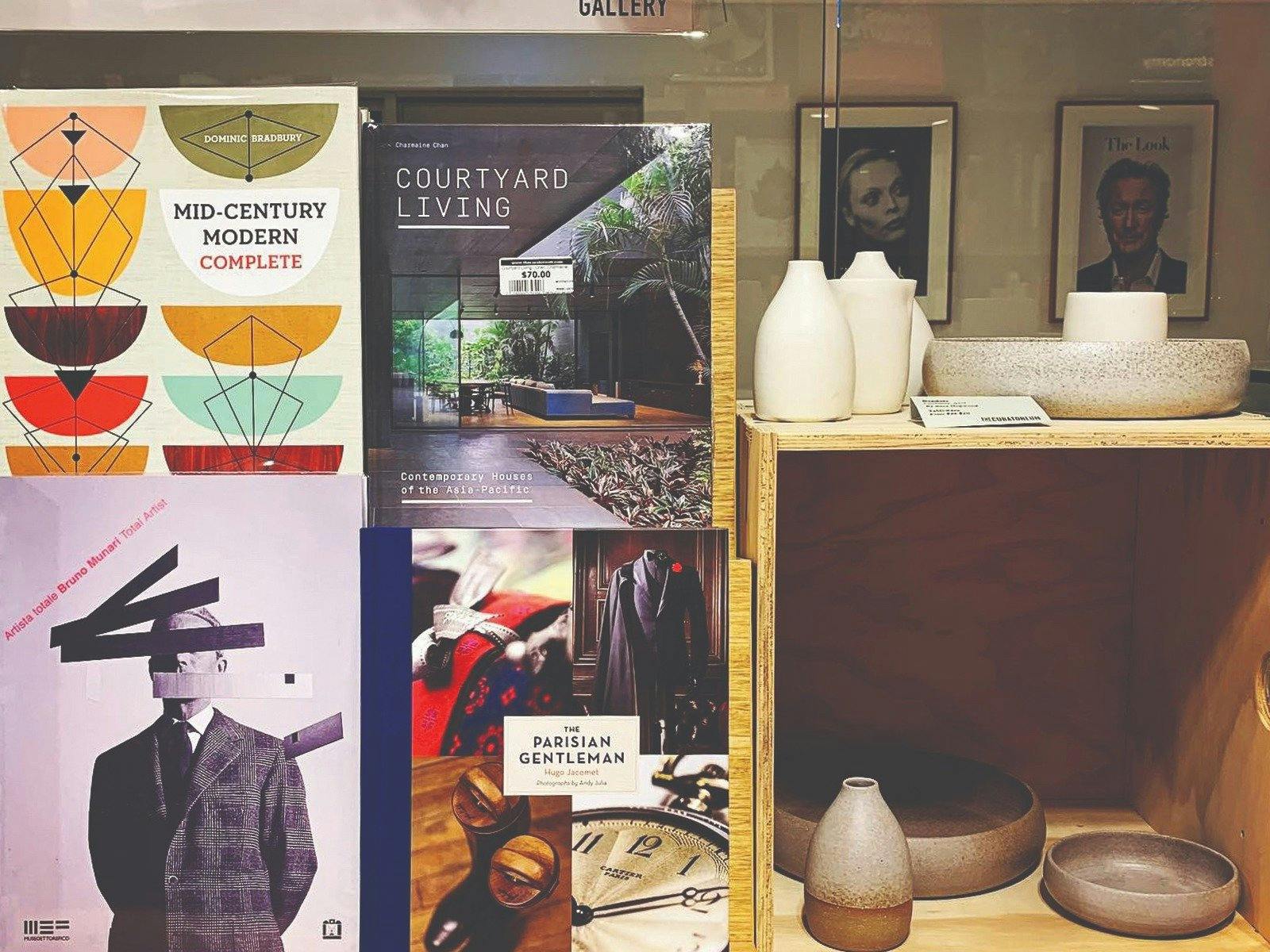 Art and fashion book covers next to ceramic bowls and vessels