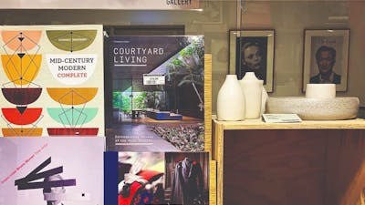 Art and fashion book covers next to ceramic bowls and vessels