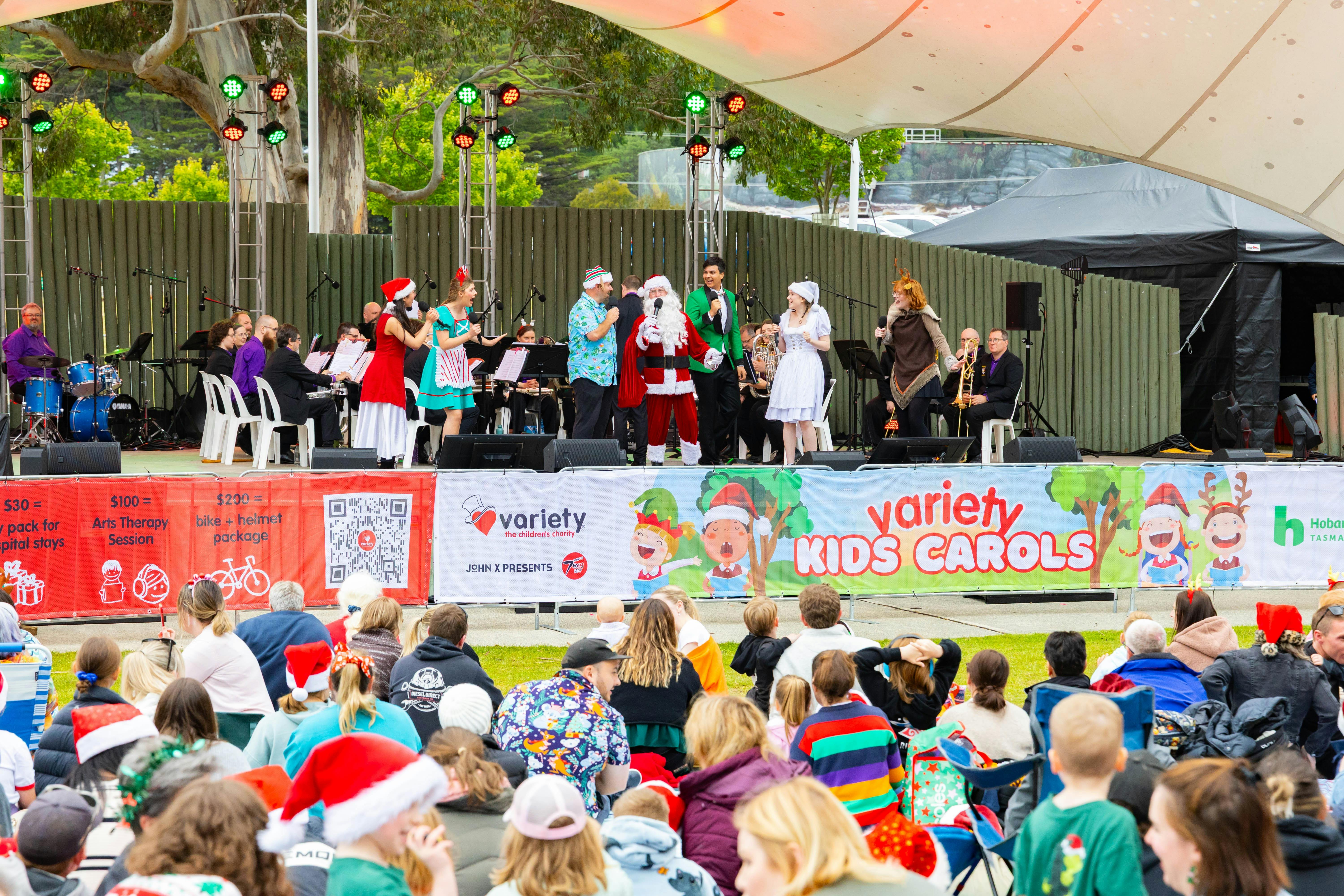 Santa and singers on stage at the Variety Kids Carols