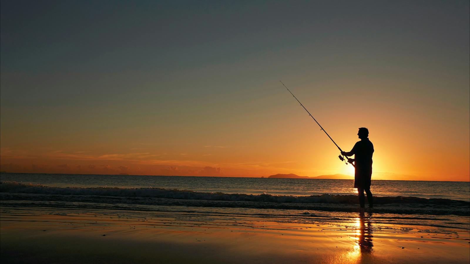 A man fishing at sunrise