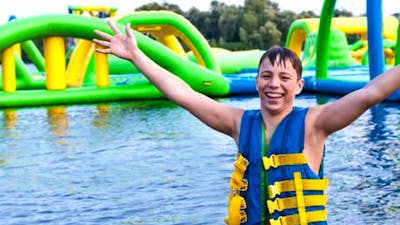 Child at waterpark with arms in the air