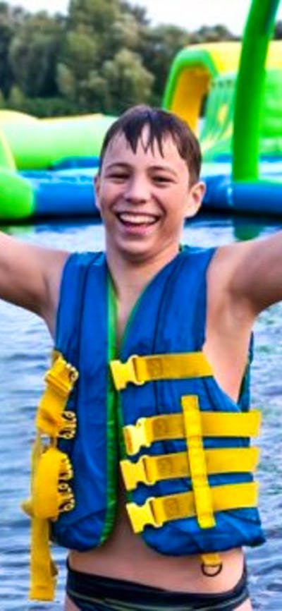 Child at waterpark with arms in the air
