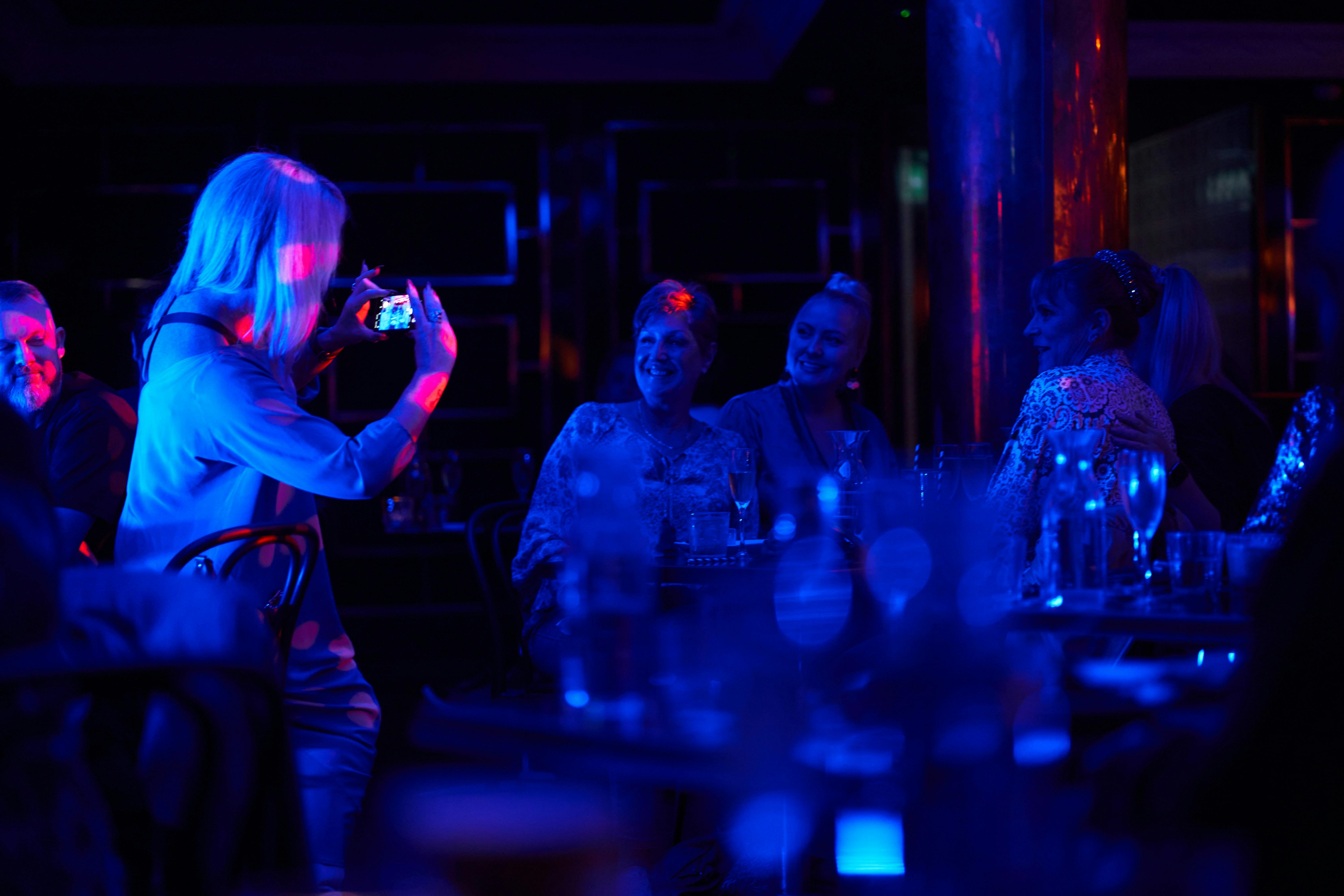 A group of middle aged women having fun at a cabaret dinner show