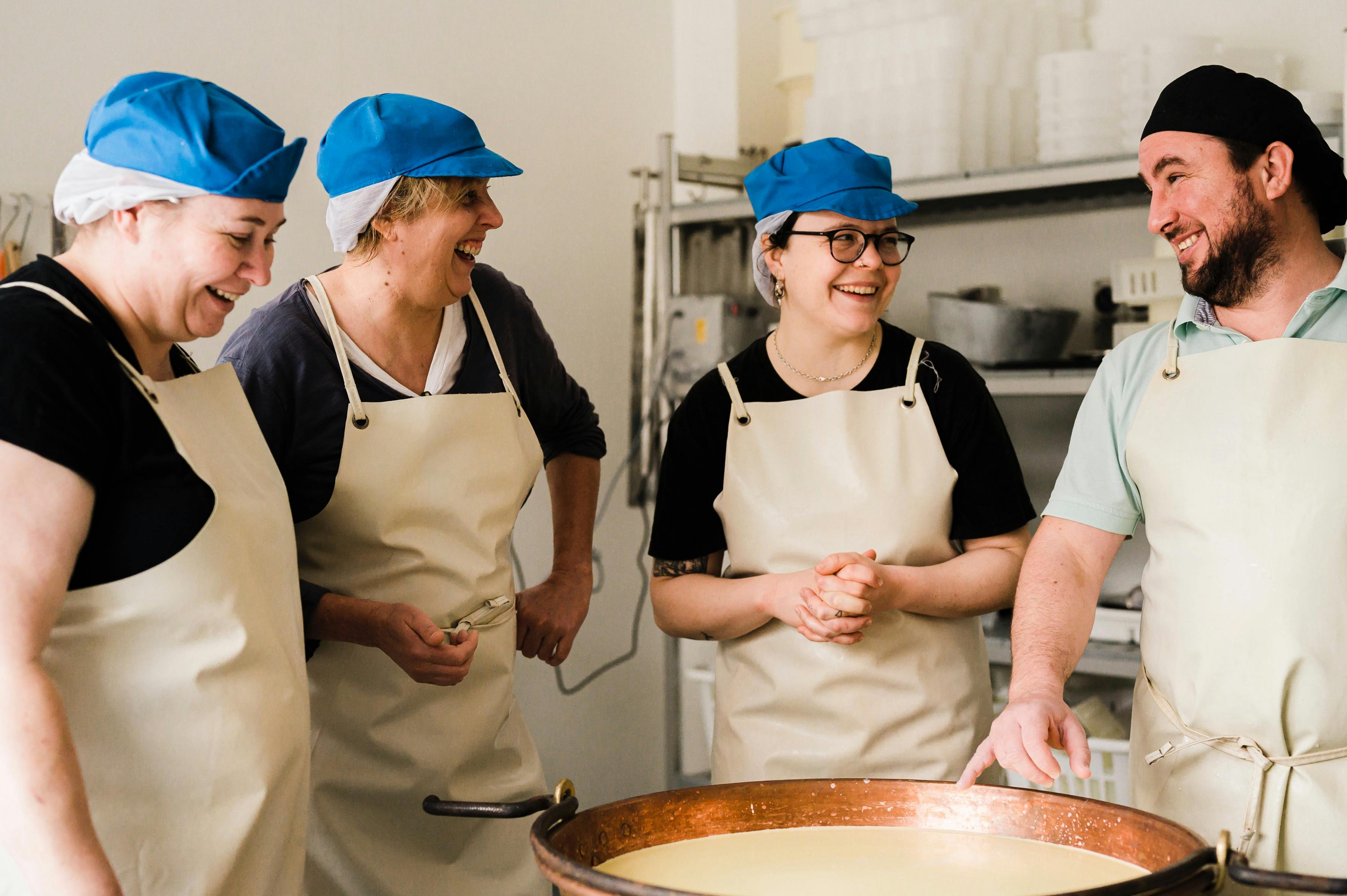 Three students and the teacher, Ivan, standing around a copper vat full of milk