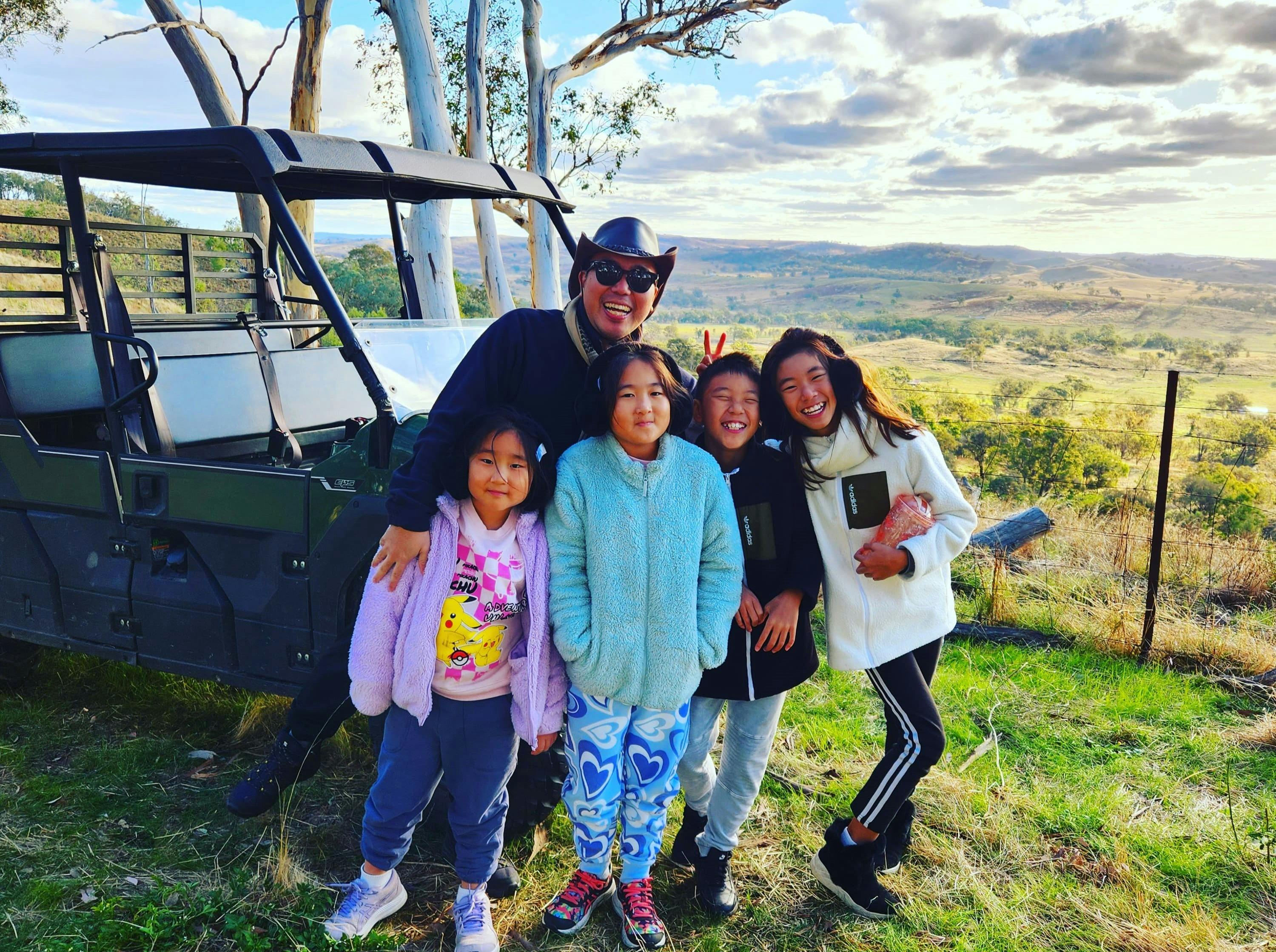 Tour buggy on top of look out with vista of rolling hills and family of Dad and four kids