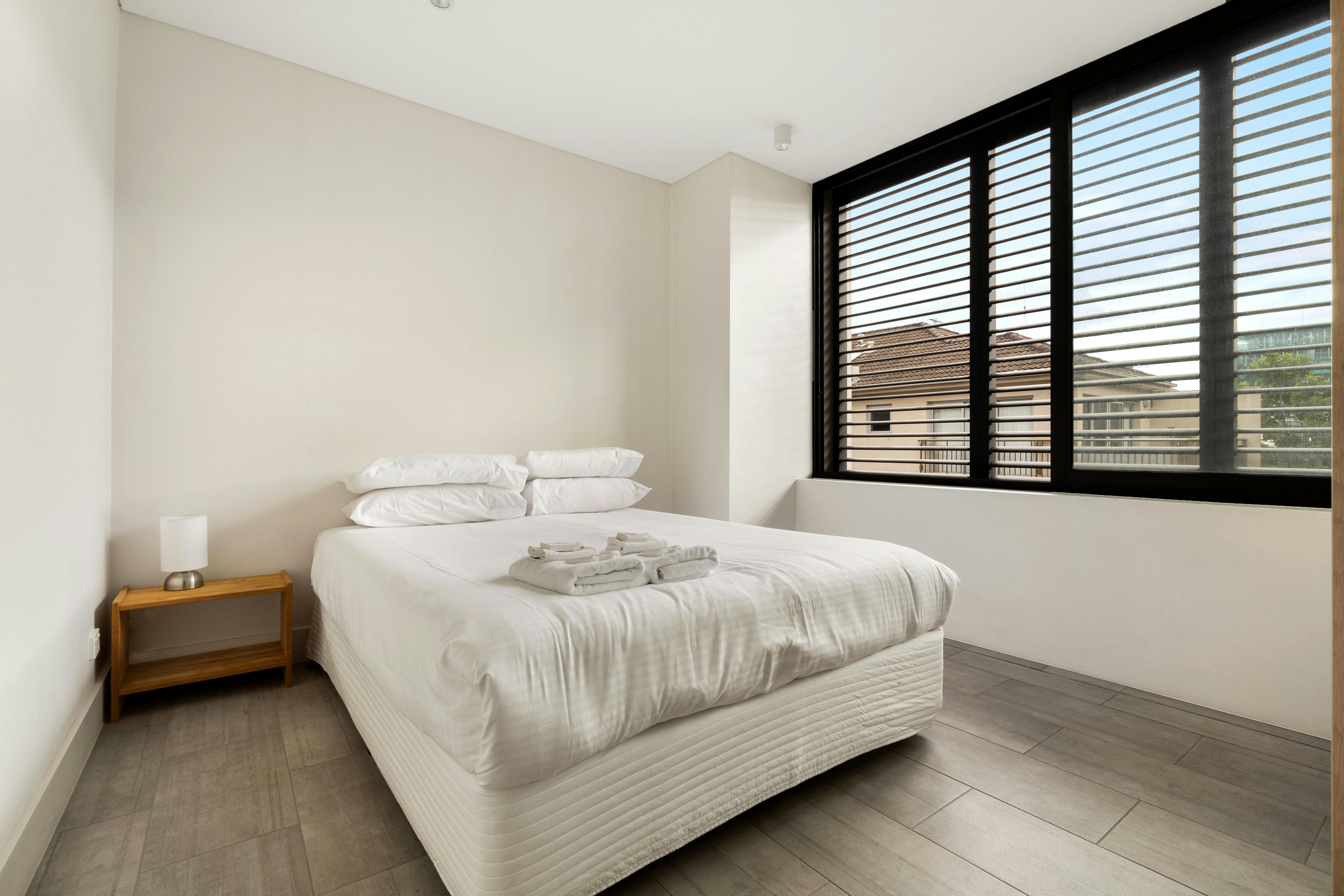 舒适的卧室，配有大窗户和舒适的床上用品。