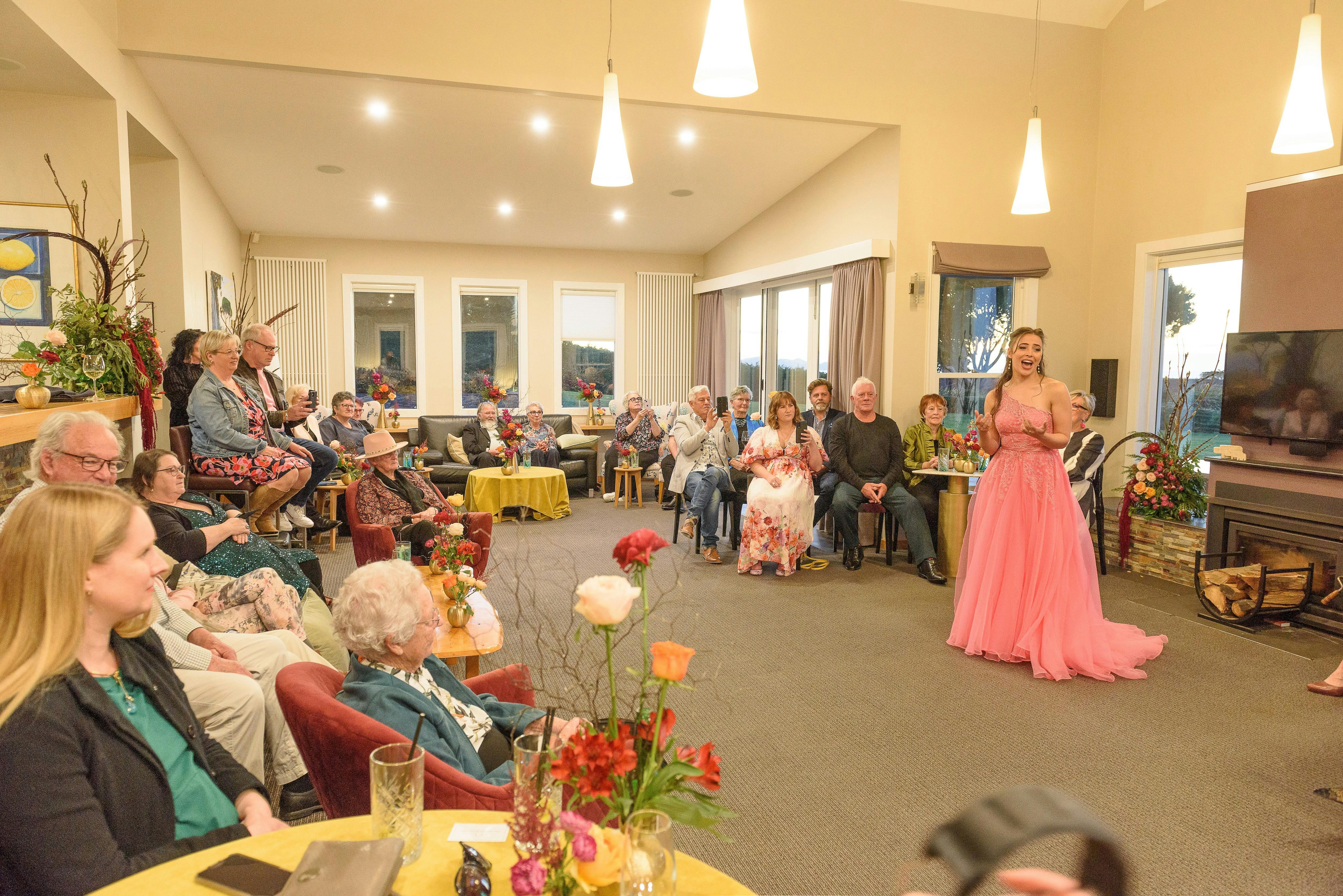 Soprano Georgia Wilkinson in a pink gown singing in Table House living room last year