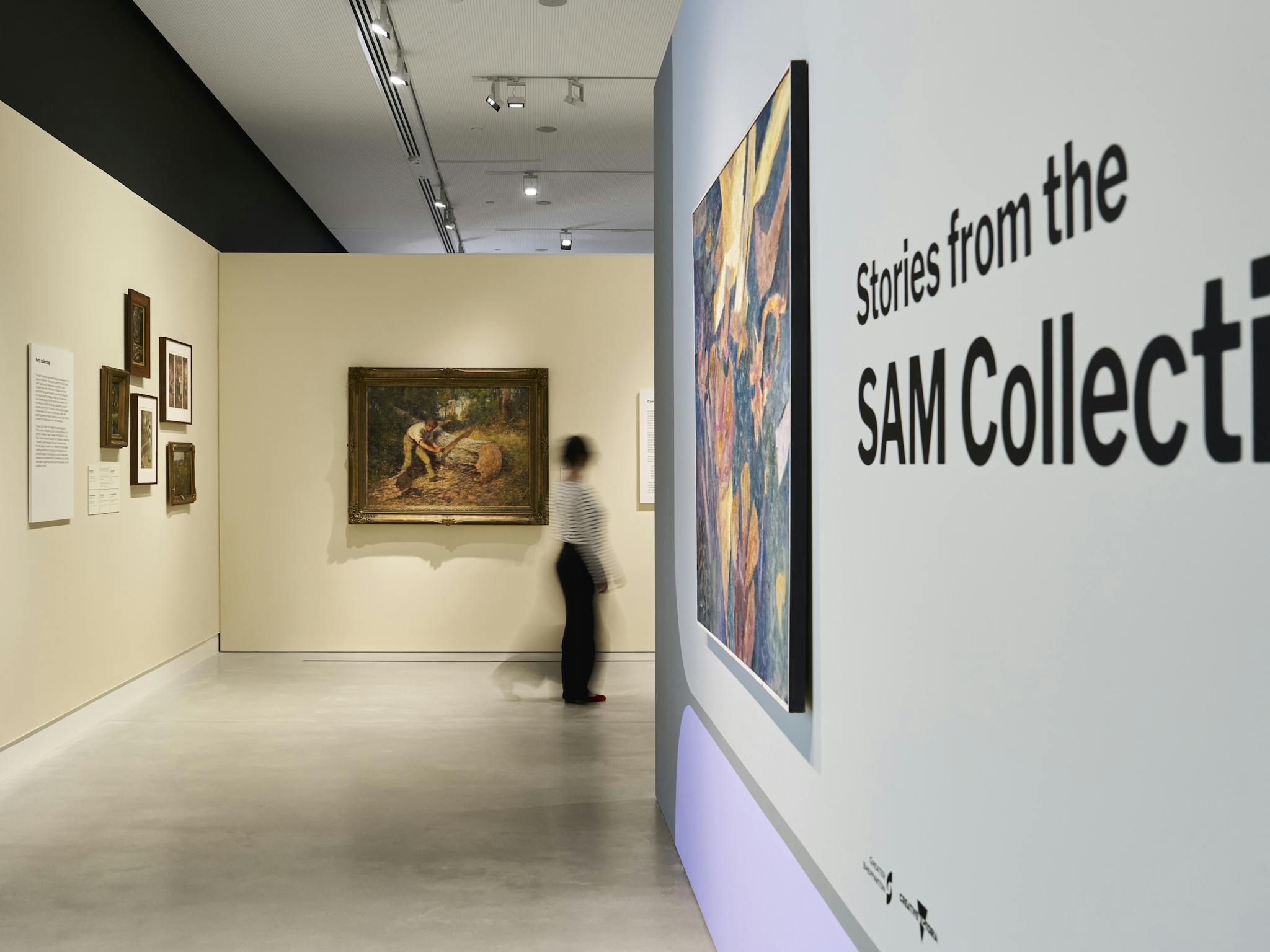 A woman walks past colonial-era paintings in an art gallery
