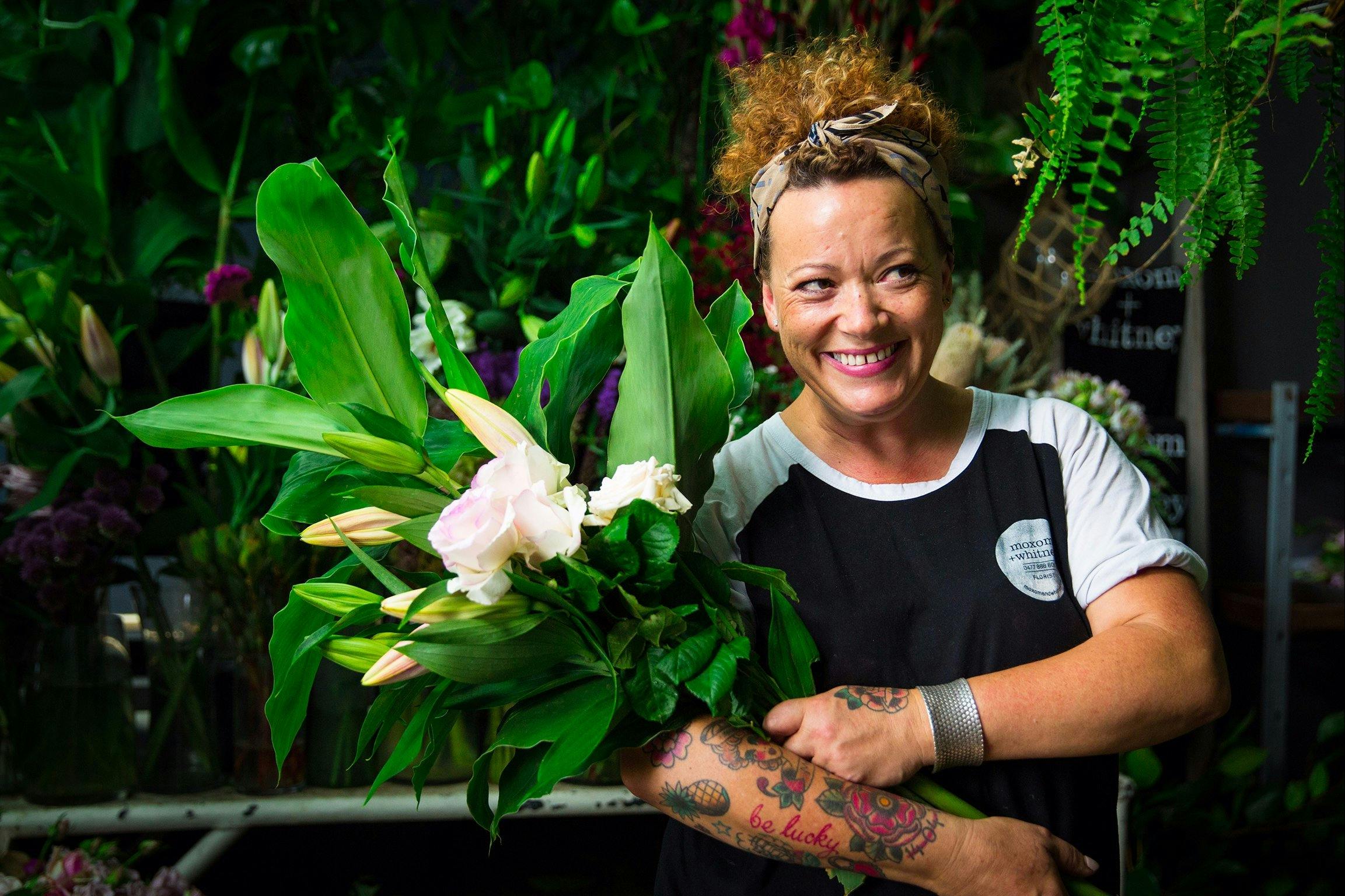 Florist with armful of beautiful blooms