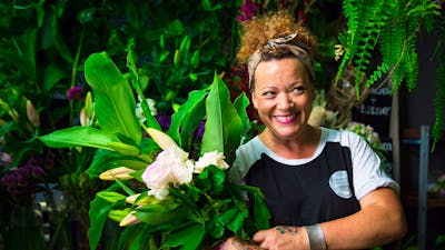 Florist with armful of beautiful blooms