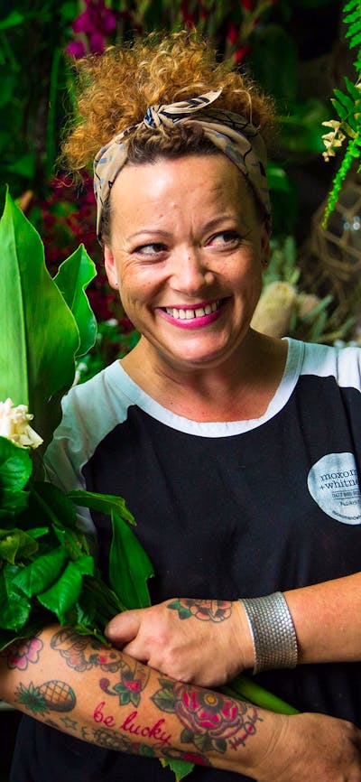 Florist with armful of beautiful blooms