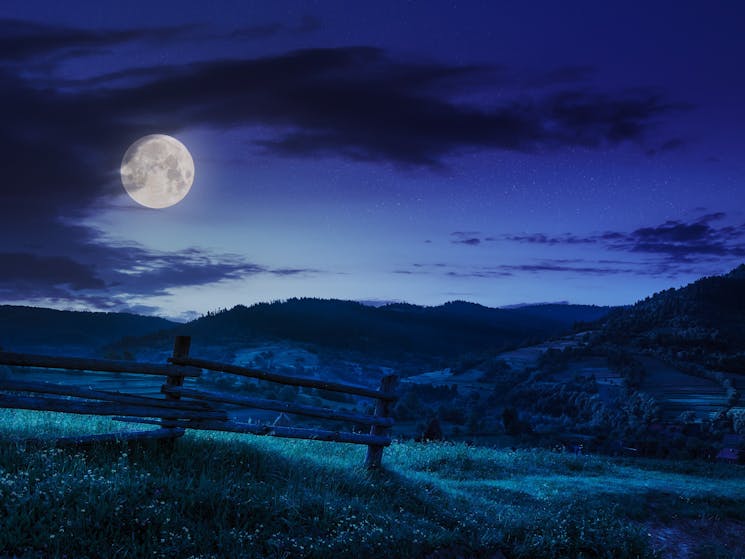 Full moon over fence and countryside
