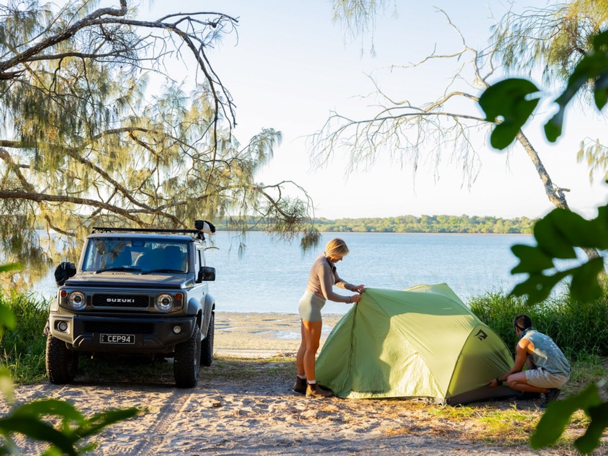 Camper setting up for the night with the water in the background