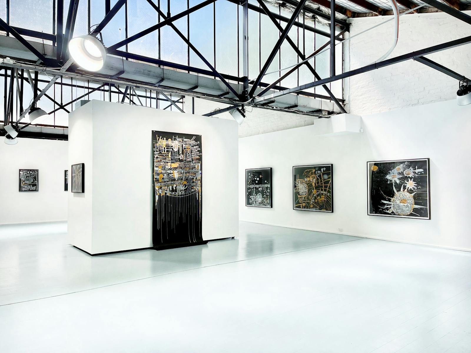 Various artworks scattered within an open, well-lit gallery space.