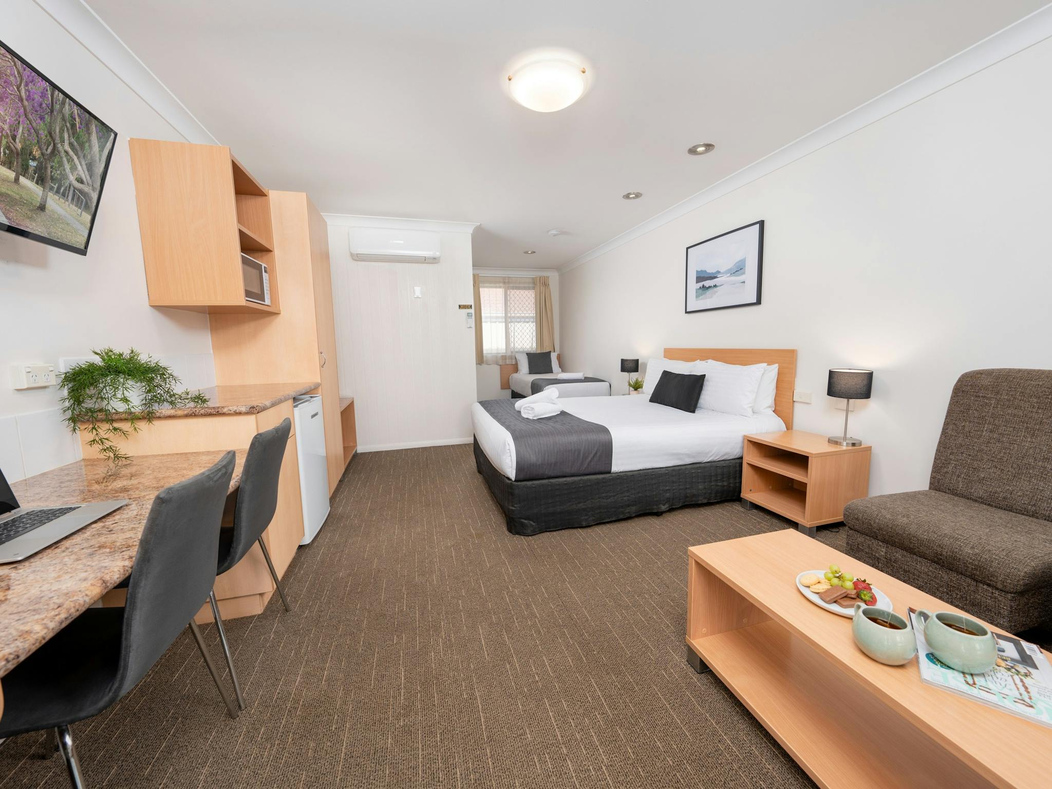 Motel Room with Queen bed, Single bed, desk space, lounge seating and coffee table. Motel Room with Queen bed, Single bed, desk space, lounge seating and coffee table.