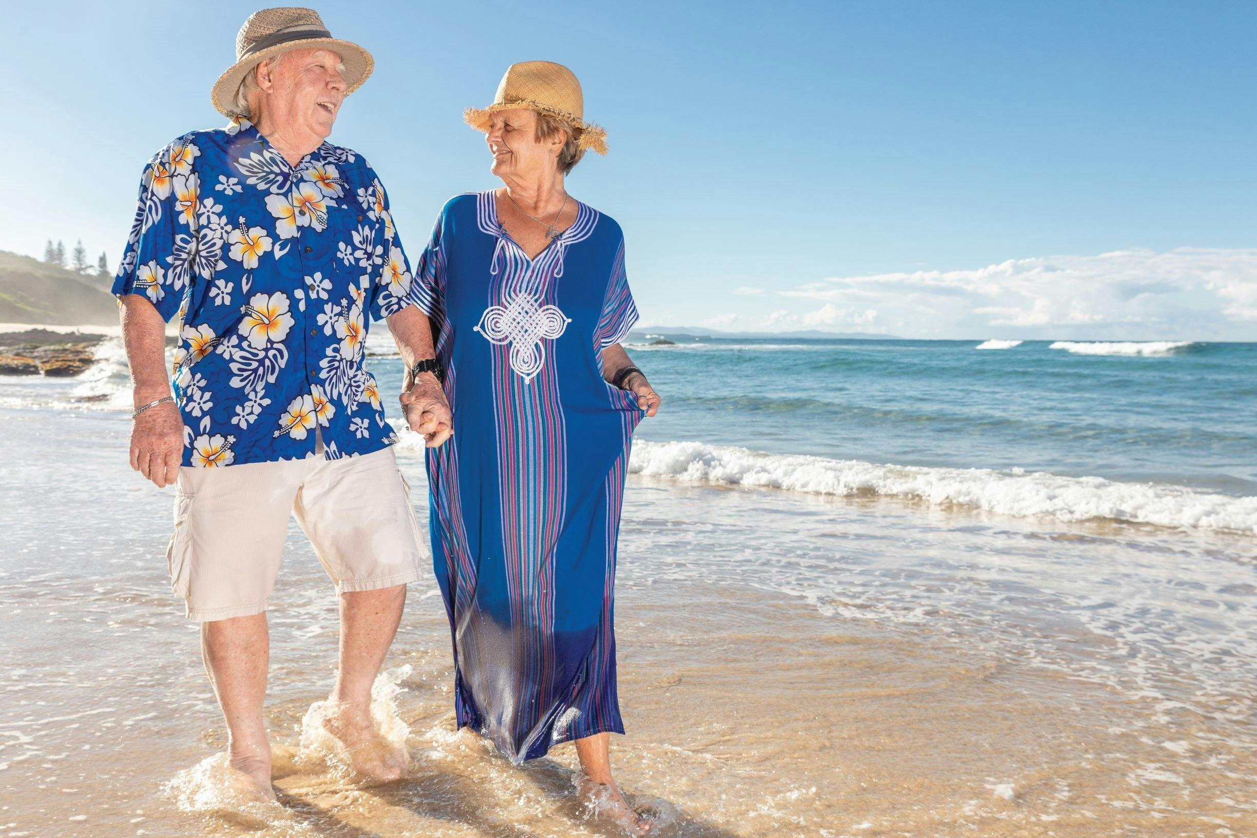 Happy seniors hand-in-hand walking along Shelly Beach