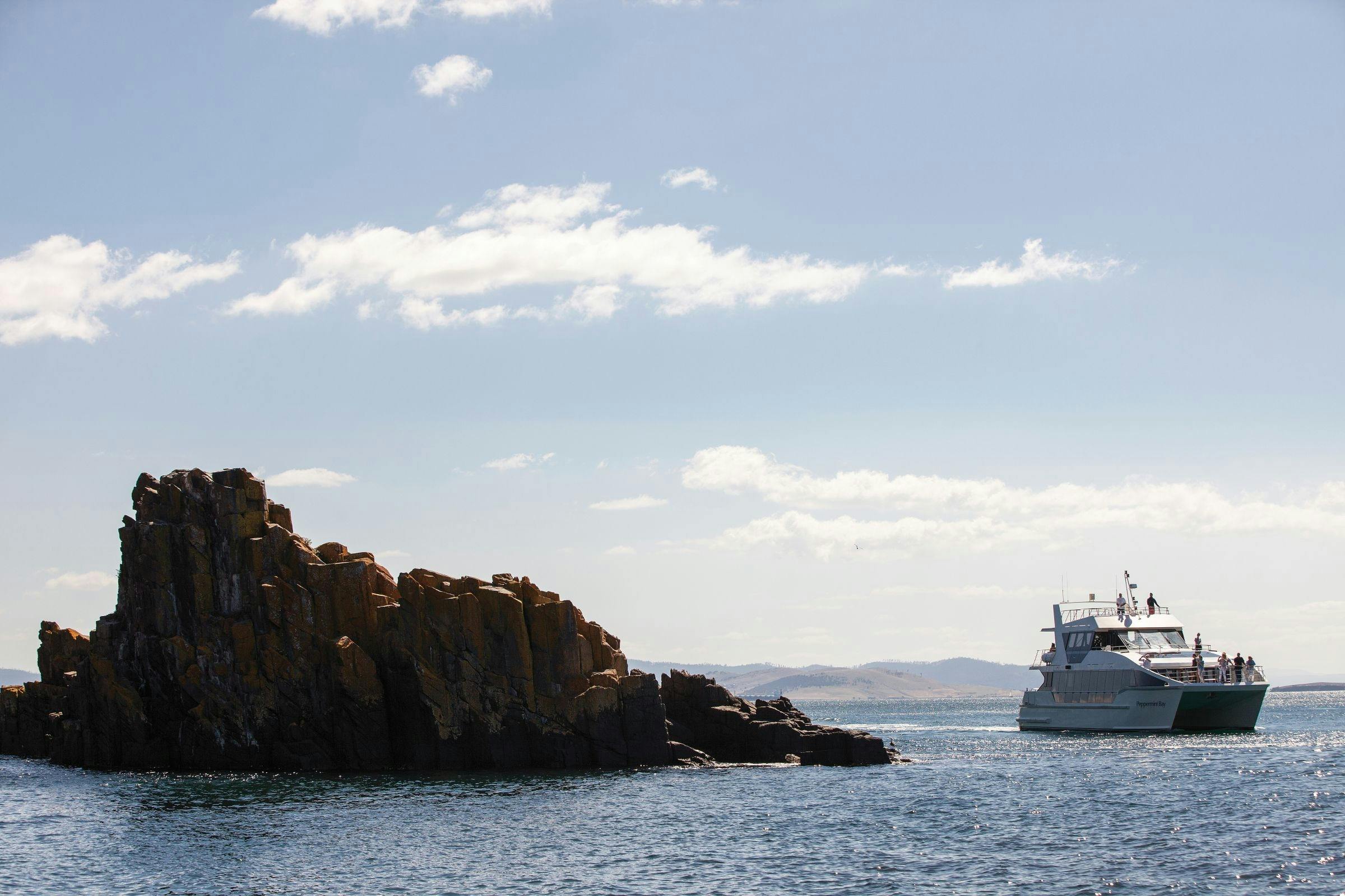 Catamaran cruising around rock formations