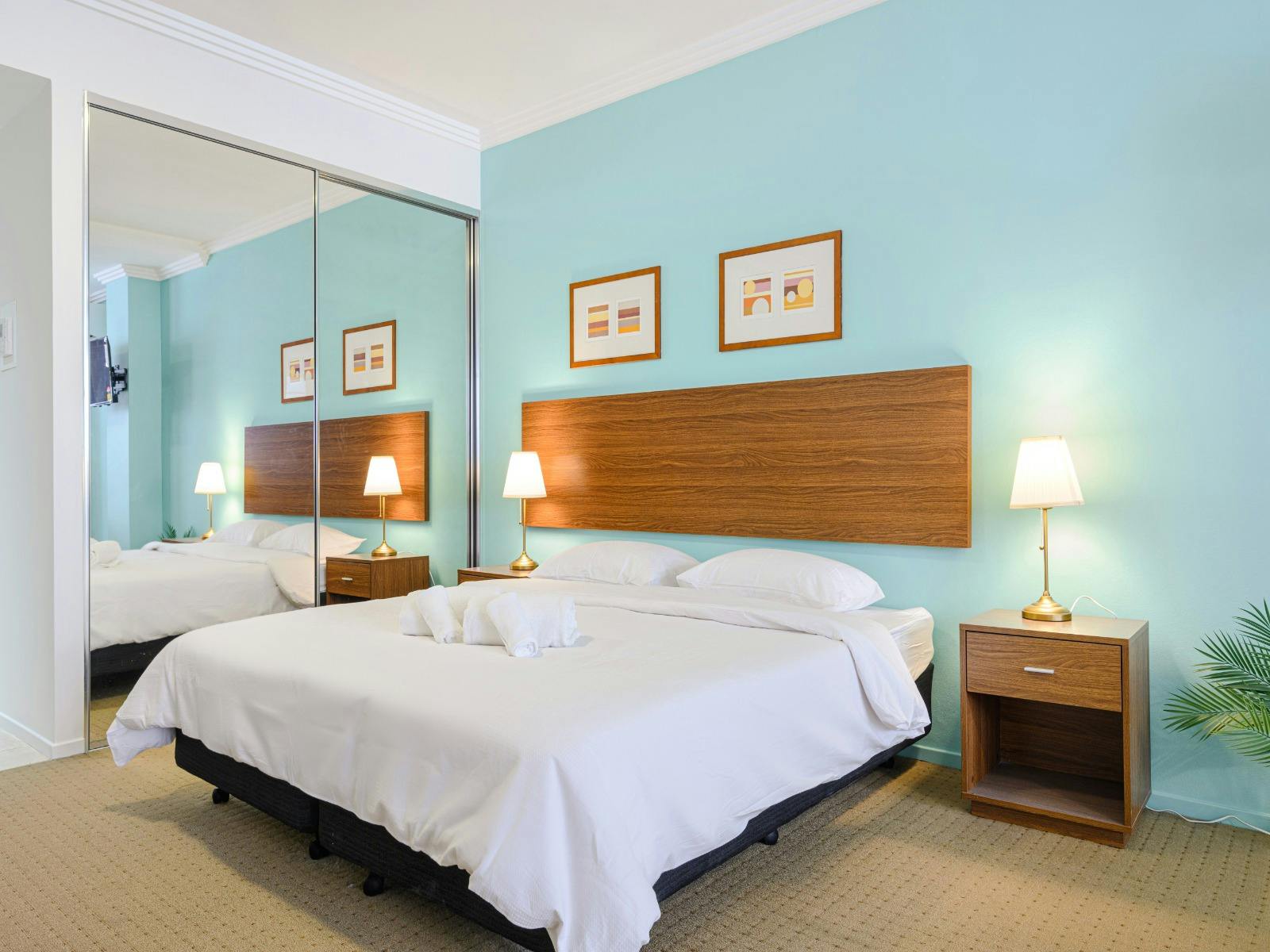 Bedroom angle highlighting the king-size bed near the entrance, mirrored wardrobe
