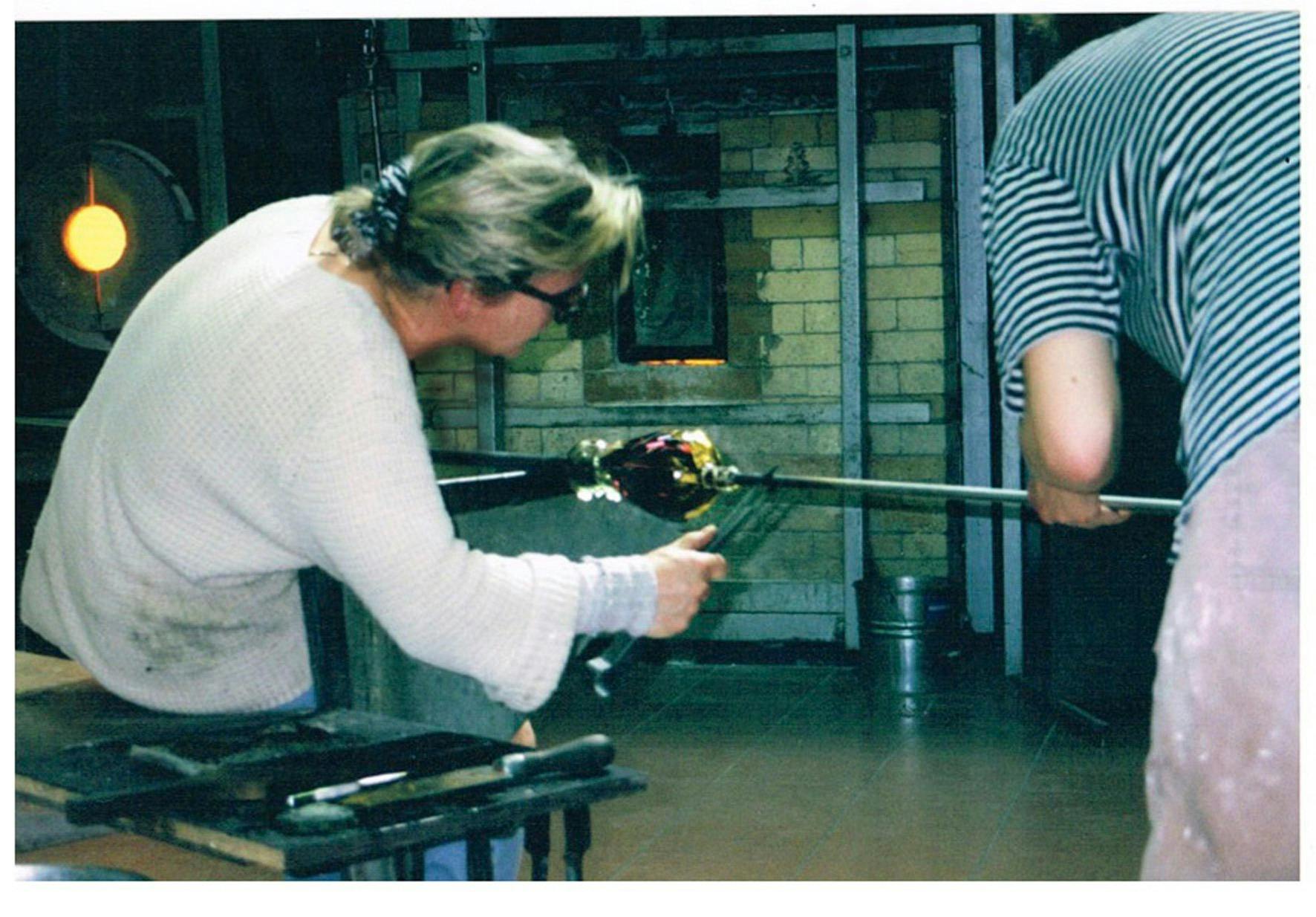 Glass artist blowing glass