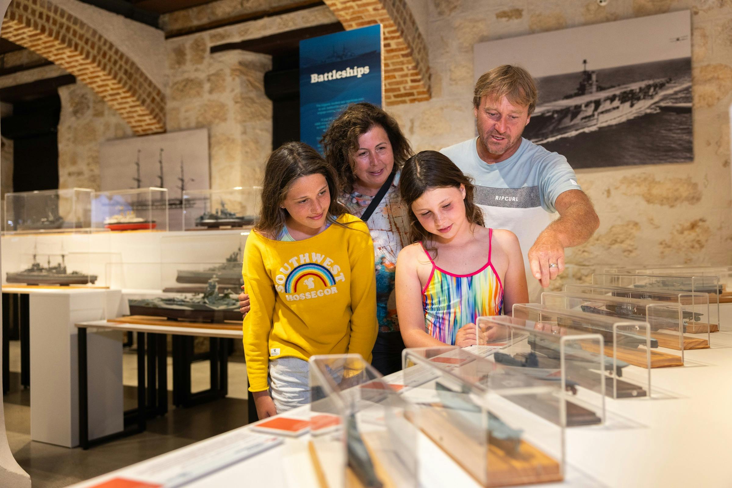 a family looking at model ships
