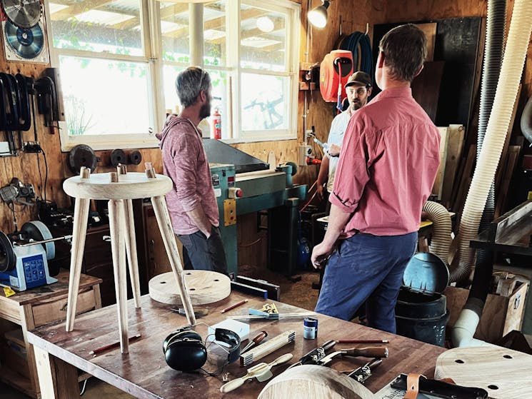 Participants working with Andy at a wood lathe