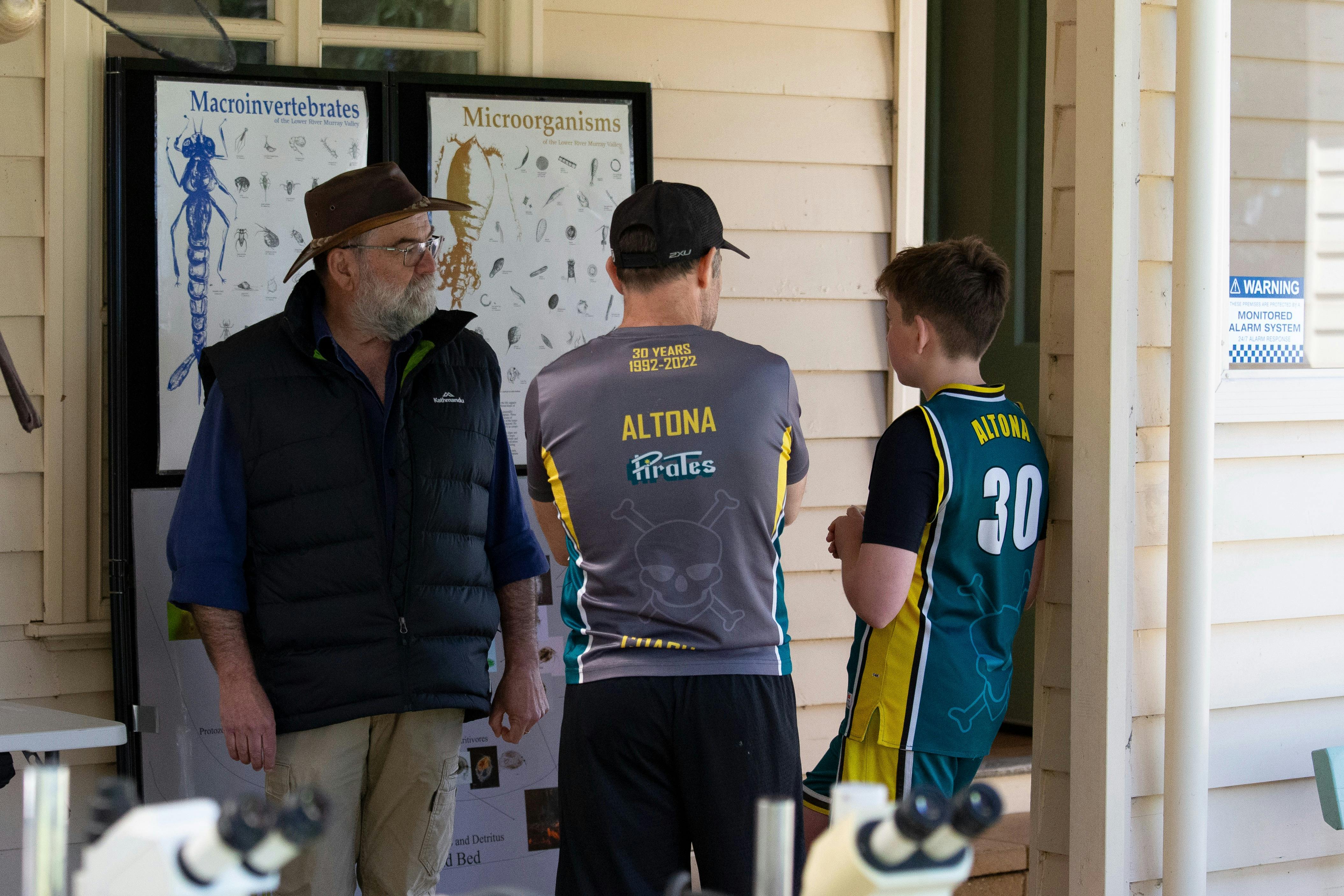 Man is speaking to a father and son about life under the water.