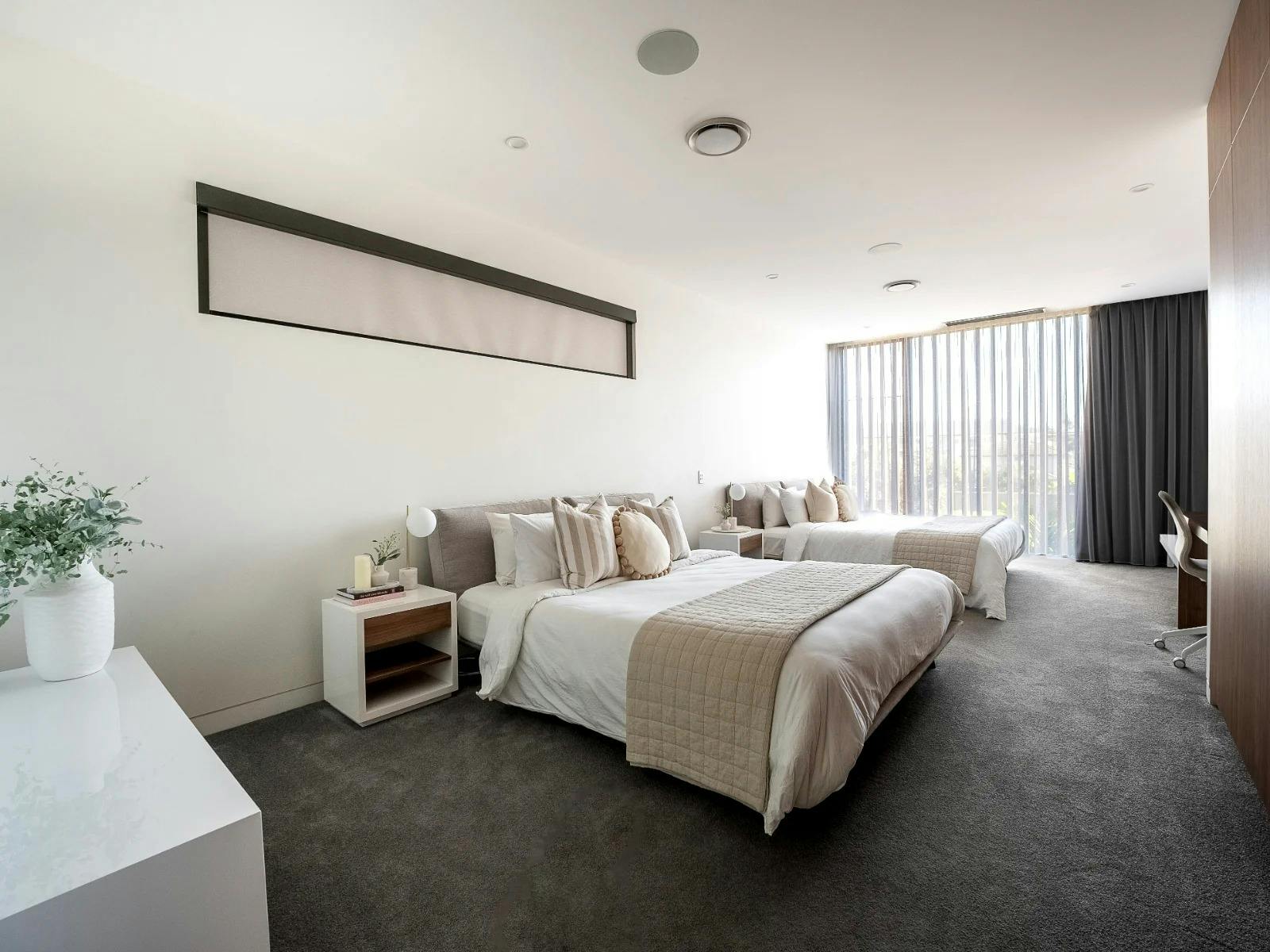 Spacious bedroom suites with premium bed linens and soft white curtains