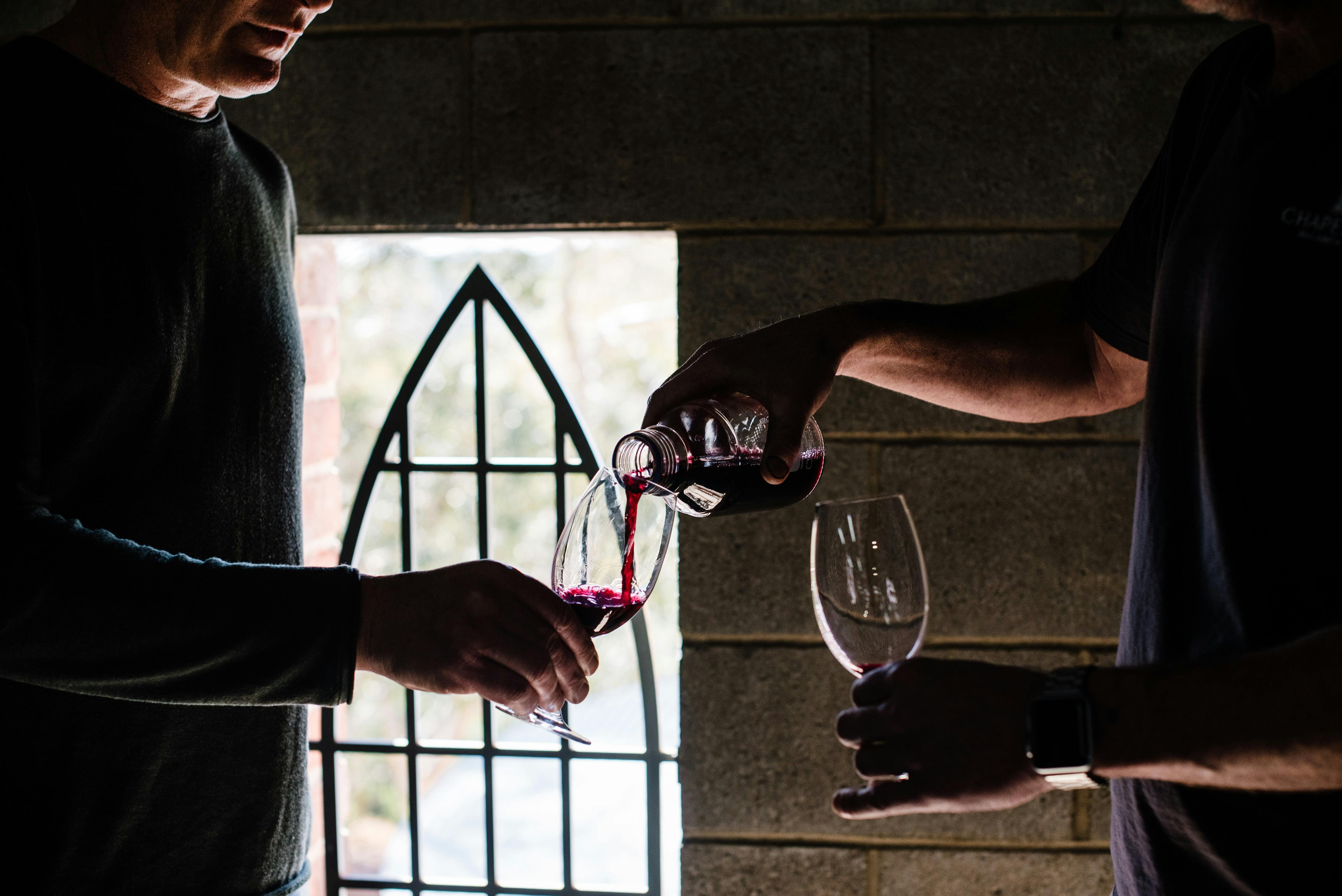 A winemaker pours a glass of wine during a winery tour at Chapel Hill
