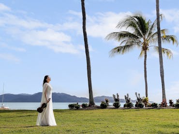 AFCM Promo image_Musician on grass in front of beach in Townsville