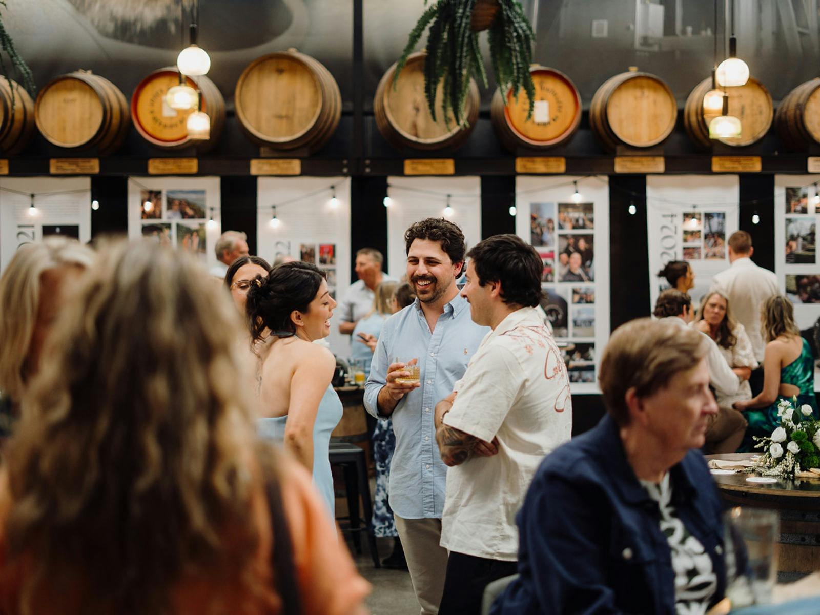 A group of casual guests enjoy an event in the Earp Distillery Barrel Hall