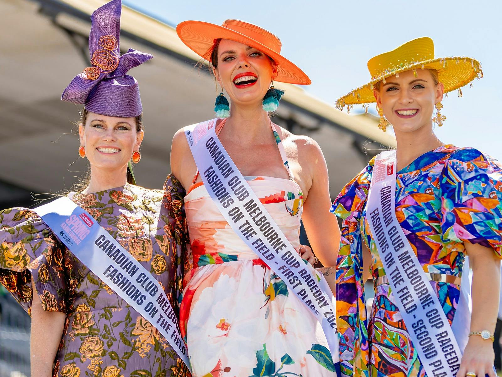 Three women with winning sashes smiling at the camera