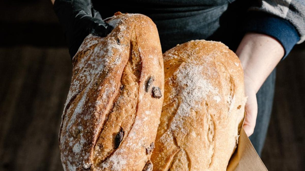 Fresh sourdough bread held by the baker at JPFM