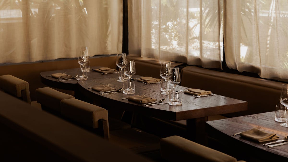 Table inside set with wine glasses with light streaming in through the windows