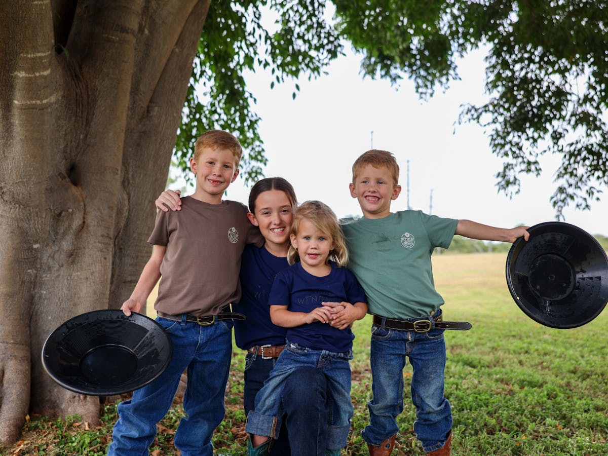 Four kids posing together with pans