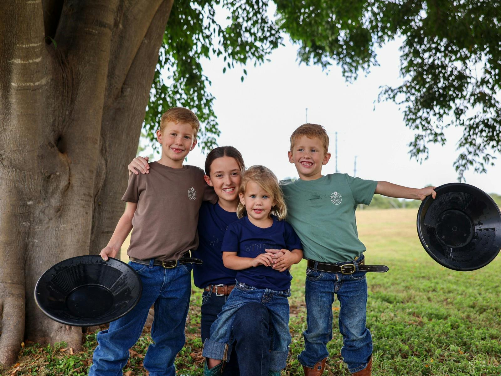 Four kids posing together with pans