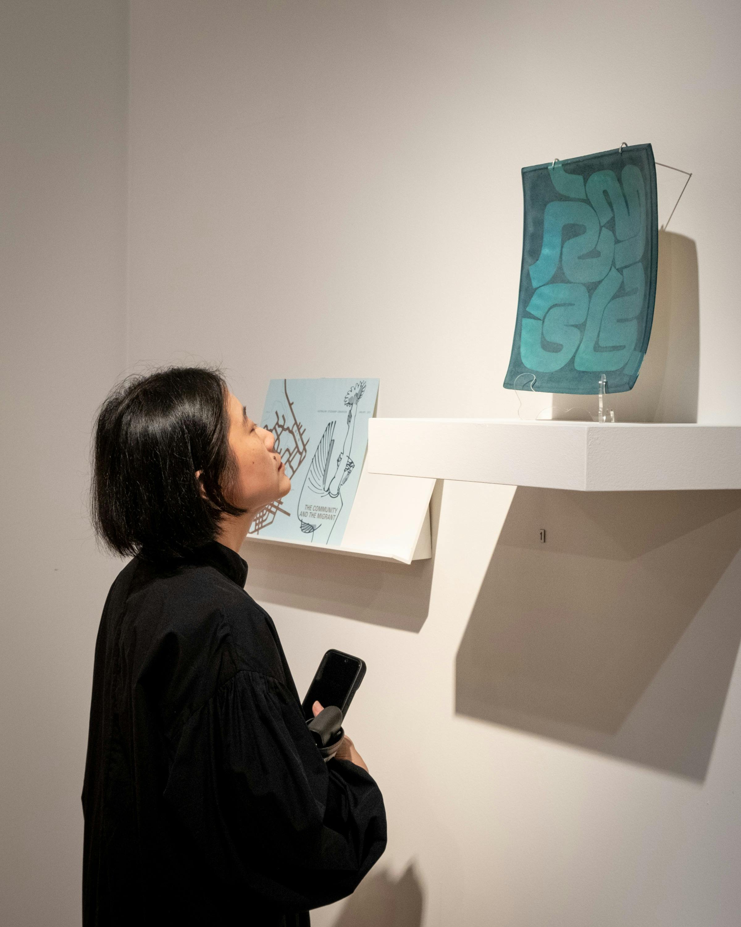 A young woman examines a ceramic work by Hiroe Swen