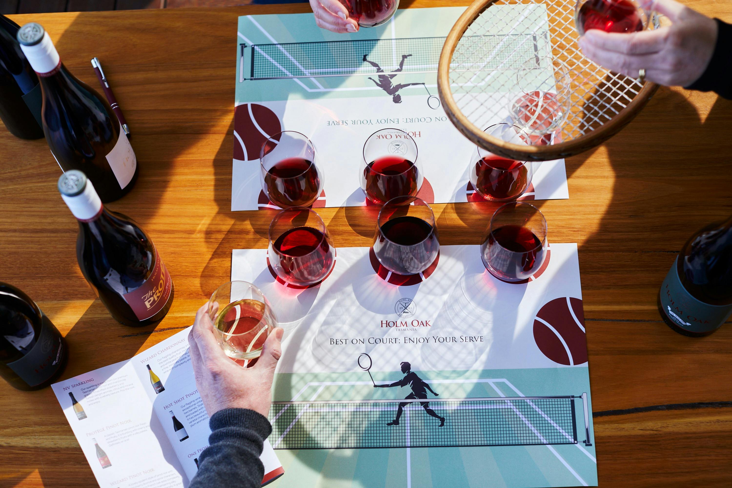 Image from aboce of wine tasting with tennis racquet and glasses of wine