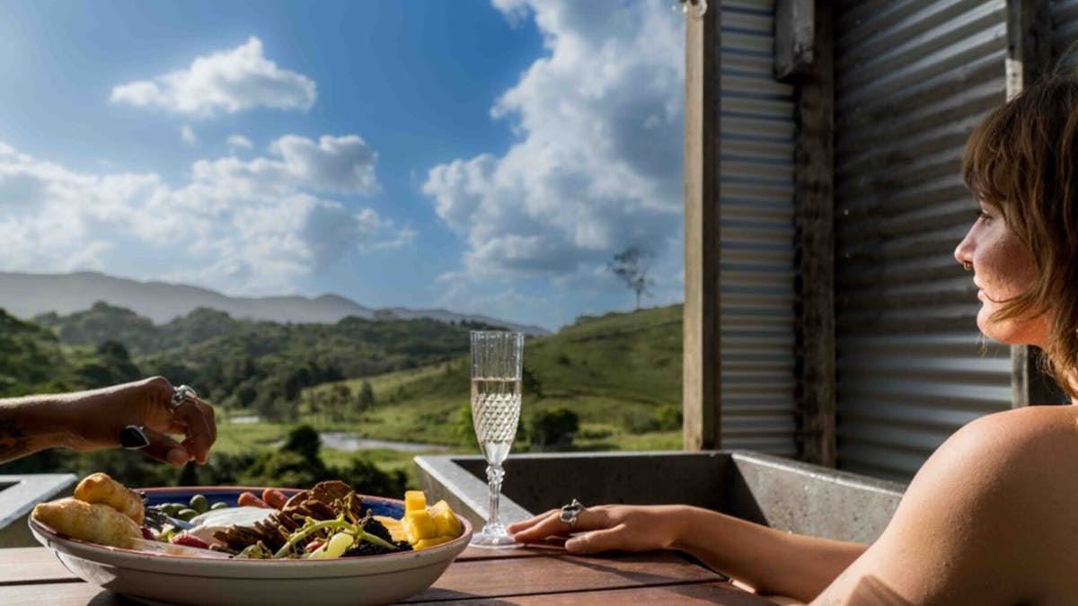 A couple enjoying the view, whilst soaking in the bathtub with their BYO food and drinks.