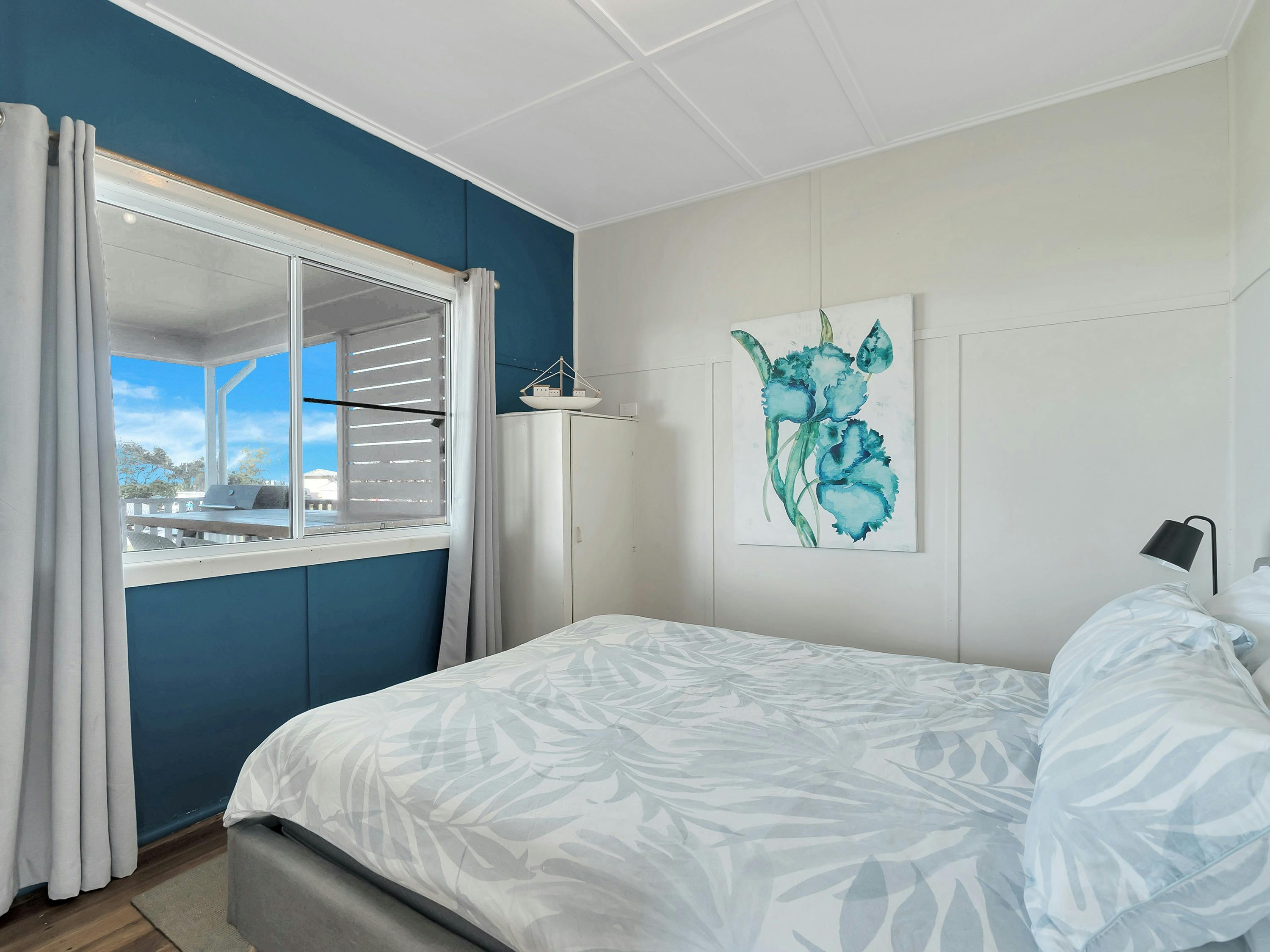 Photo of the master bedroom at the front of the house with views across the front deck to the ocean.